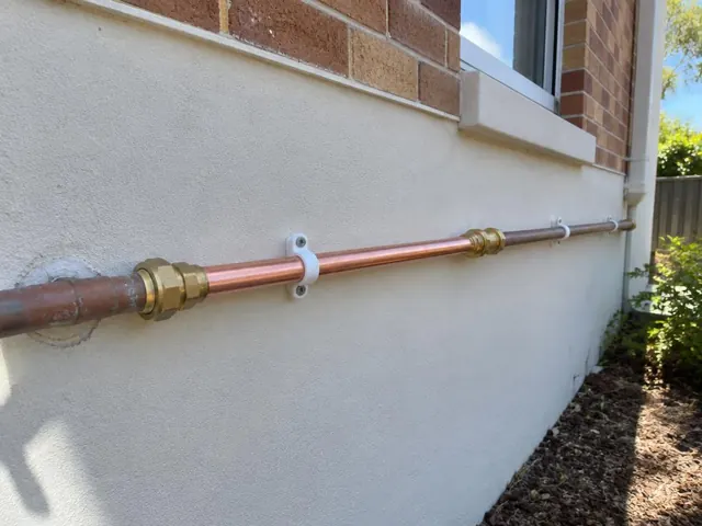 Repaired copper water pipe on an exterior brick and rendered wall in Mount Colah